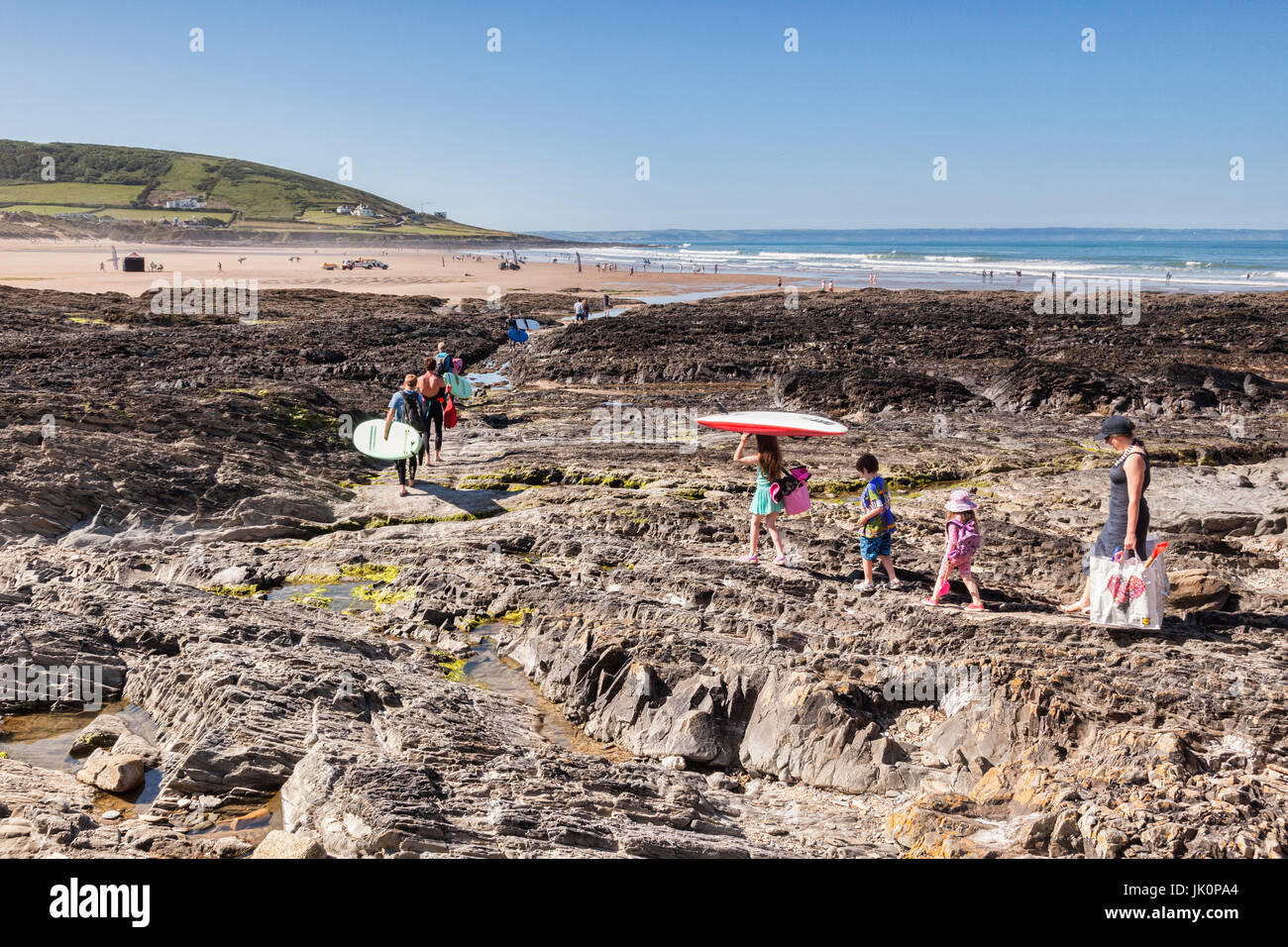 18 Giugno 2017: Croyde Bay, North Devon, Inghilterra, Regno Unito - famiglie e surfisti fanno la loro strada per la spiaggia su uno dei giorni più caldi dell'anno. Foto Stock