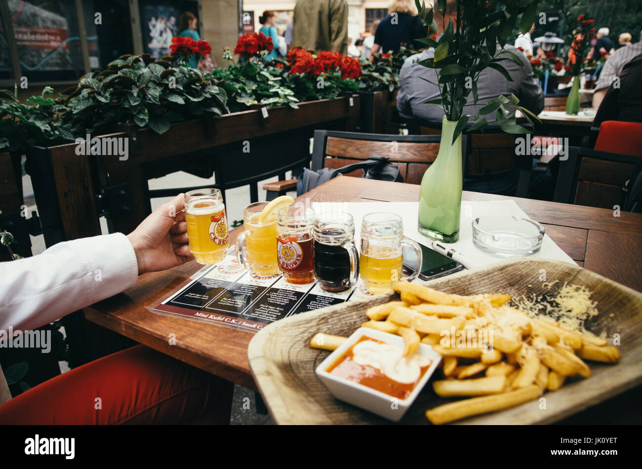 Cracovia in Polonia - Giugno 27, 2015: Test di birra con un sacco di birre diverse. Una mano holdes un bicchiere di birra. Foto Stock