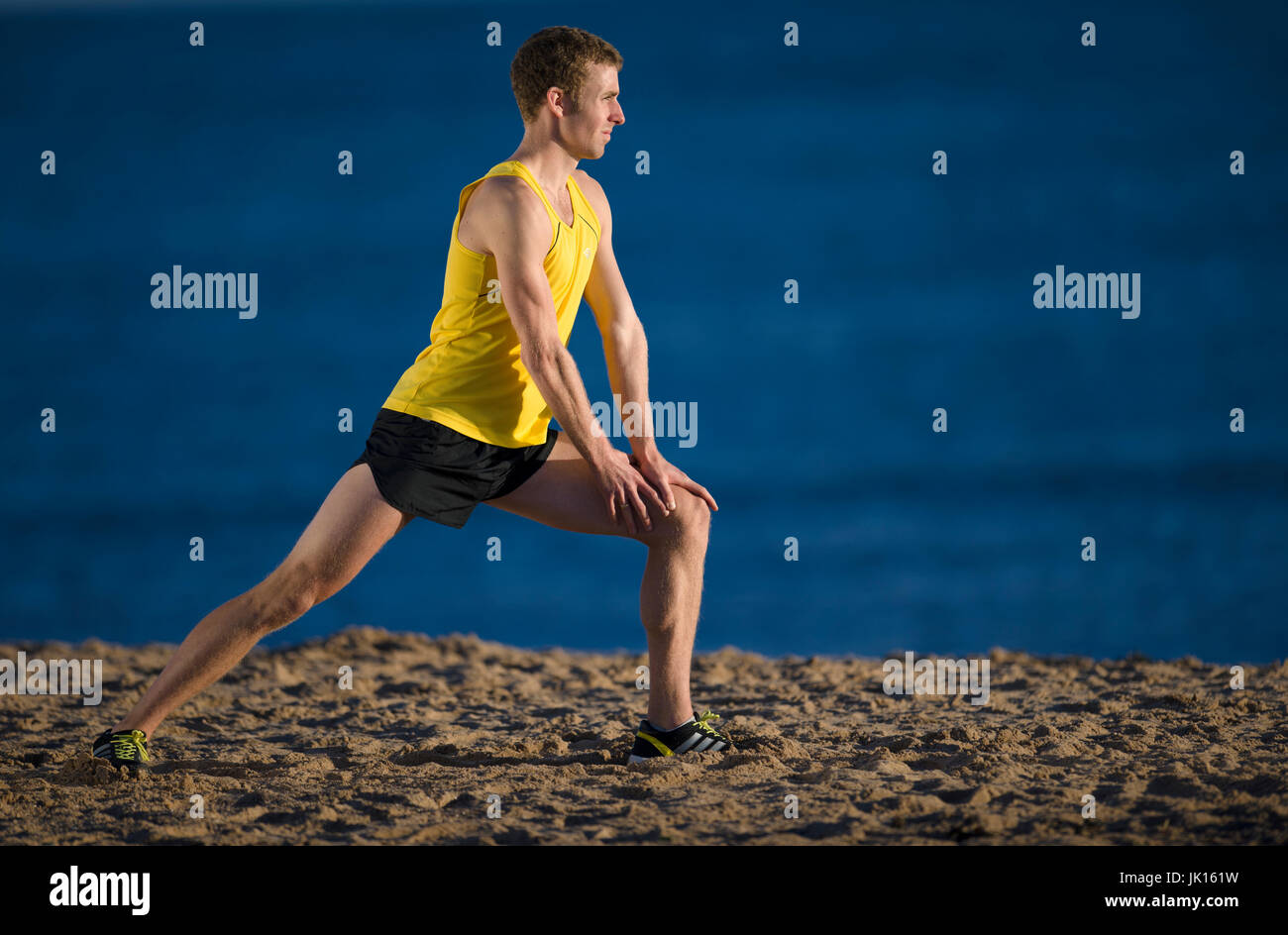 Runner riscaldare lo stiramento dei muscoli delle gambe Foto Stock