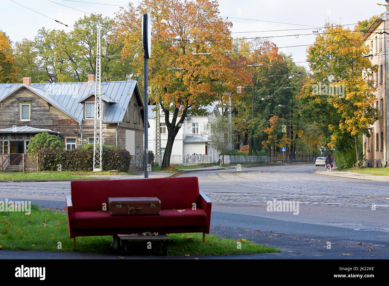 Riga, Lettonia - 12 Ottobre 2012: sulla strada abbandonati vecchio divano e la valigia Foto Stock