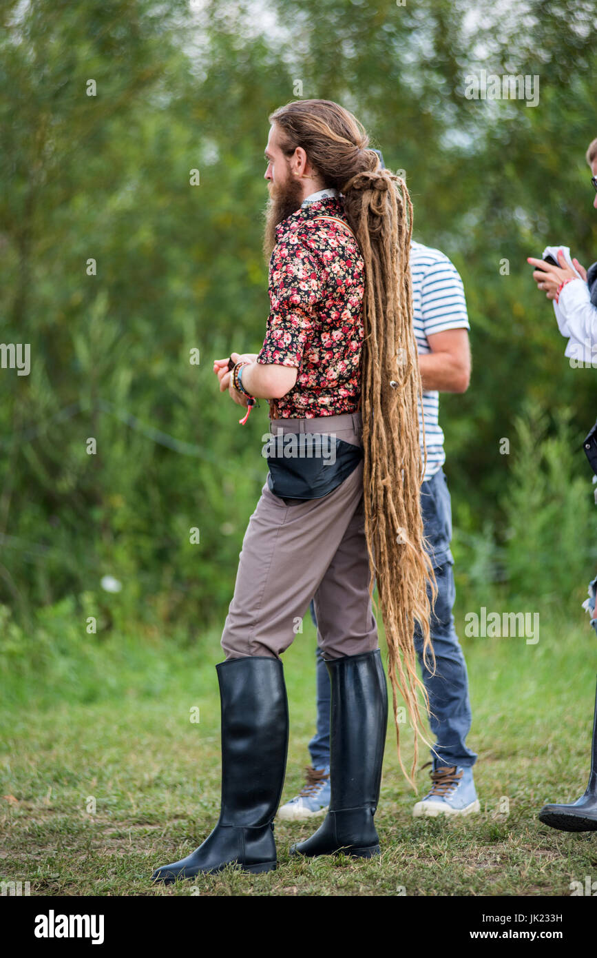 BONTIDA, ROMANIA - Luglio 16, 2017: bionda e giovane uomo con lunghi dreadlocks rasta e nero equitazione stivali godendo Electric festival di castello Foto Stock