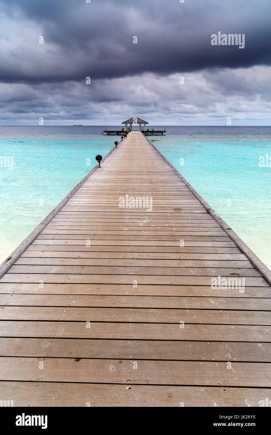 Pontile in legno sul bellissimo Oceano maldiviano con cielo blu Foto Stock