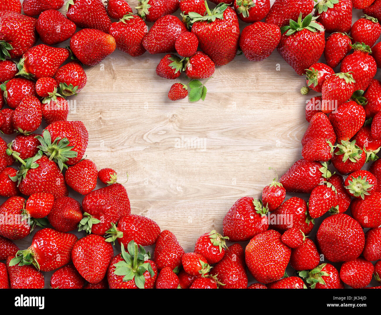 A forma di cuore fatta di fragole su sfondo di legno. Dieta frutta concetto. Close up. Vista dall'alto. Alta risoluzione Foto Stock