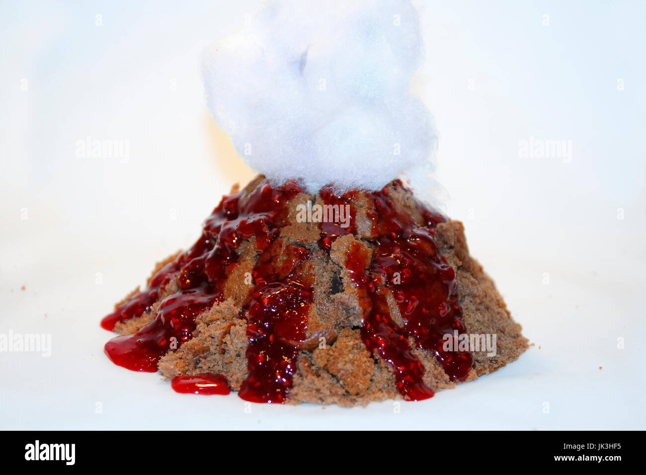 Vulkan Kuchen mit Himbeer Lava Soße und Zuckerwatte Rauch Foto Stock