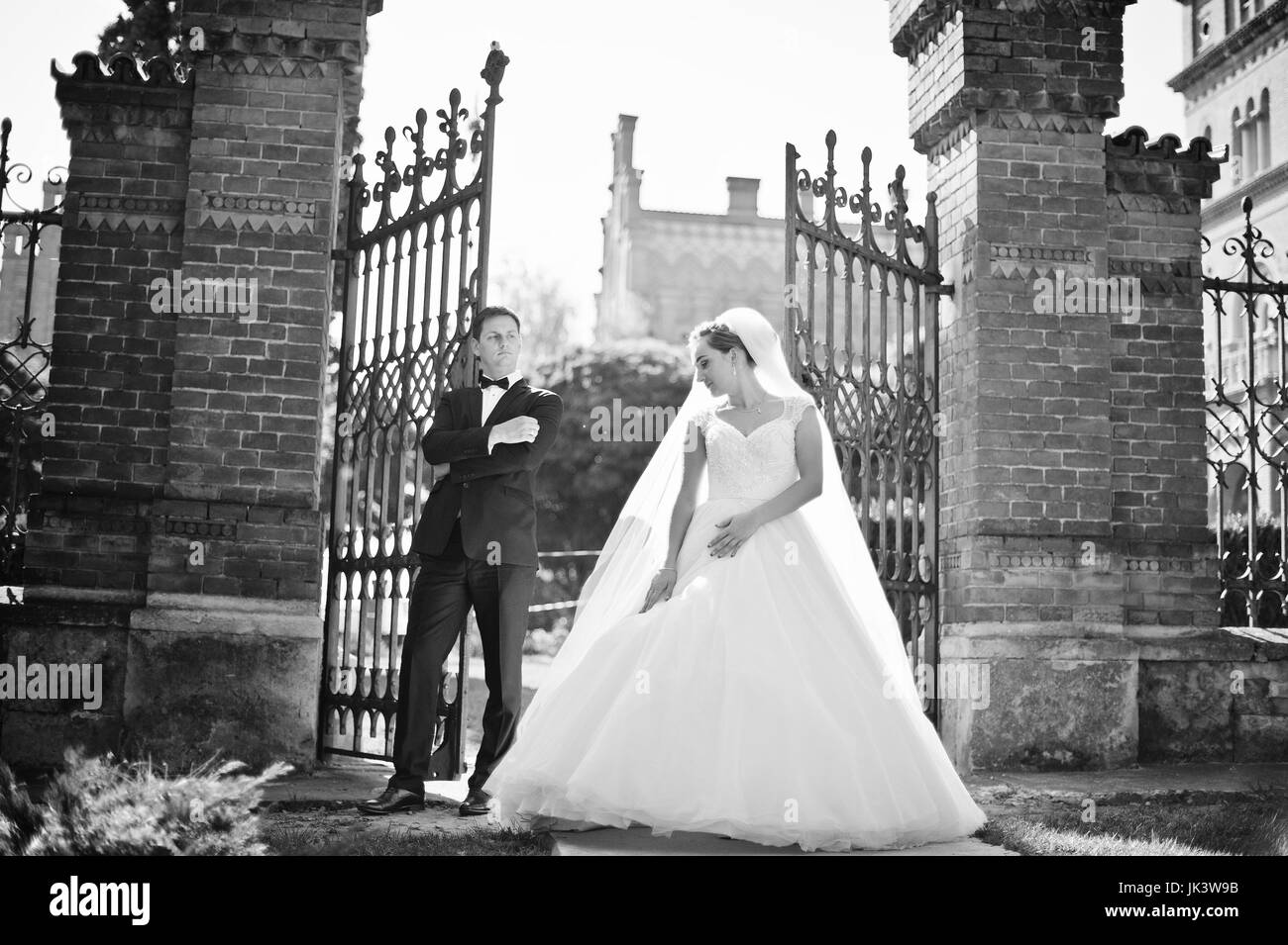 Sposi in posa vicino alle porte il loro giorno delle nozze. Foto in bianco e nero. Foto Stock