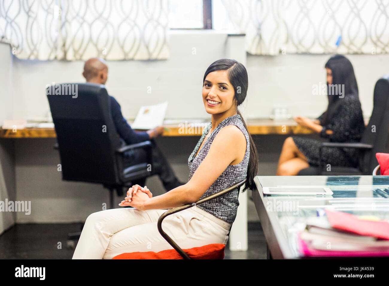 Ritratto di sorridere donna asiatica seduto in ufficio Foto Stock