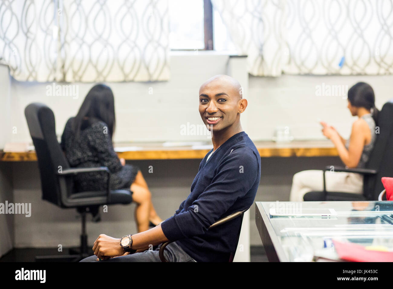 Ritratto di sorridere African American uomo seduto in ufficio Foto Stock
