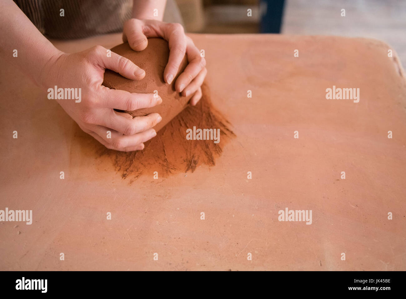 Le mani della donna caucasica laminazione di argilla in ceramica Foto Stock