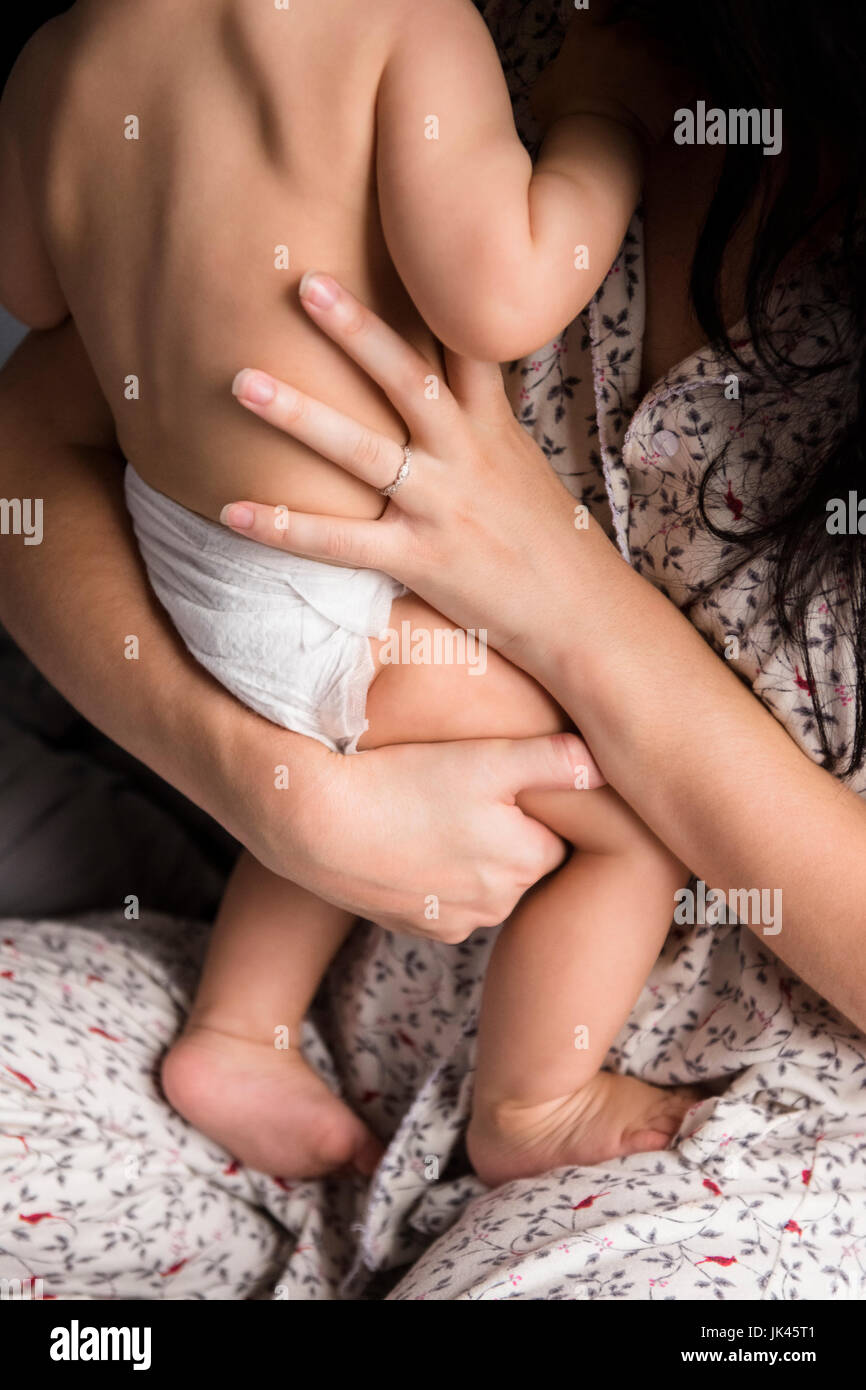 Madre caucasica holding baby figlio nel letto Foto Stock