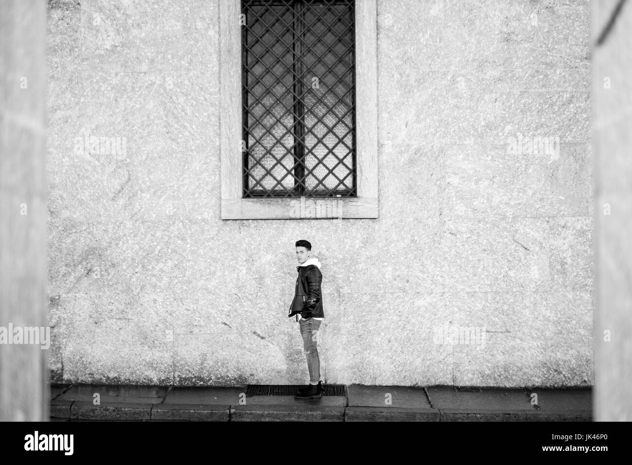 Ritratto di lontani uomo in piedi al di sotto della finestra sul marciapiede Foto Stock