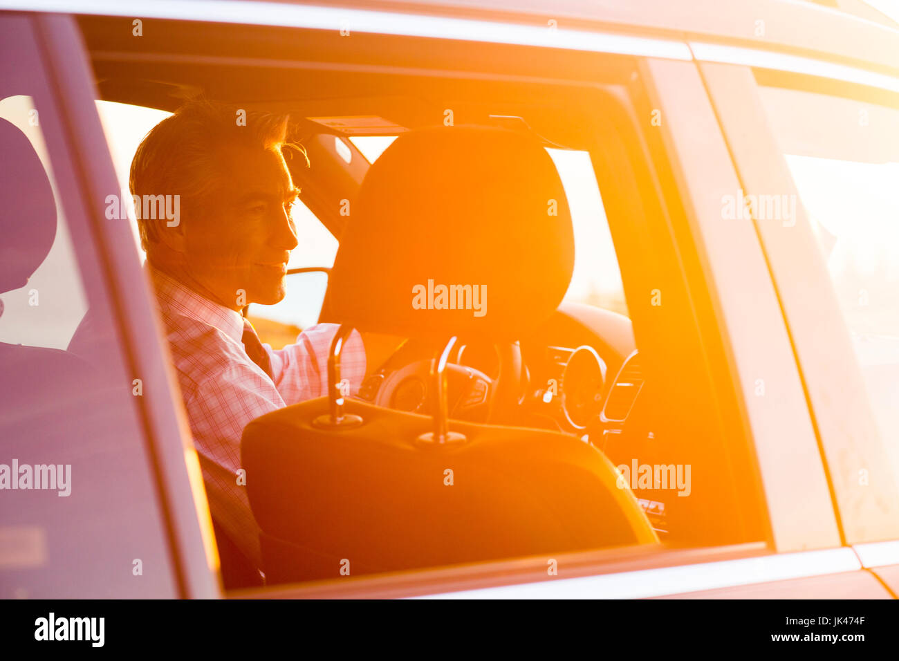 Sorridente imprenditore caucasica la guida auto sulla giornata di sole Foto Stock