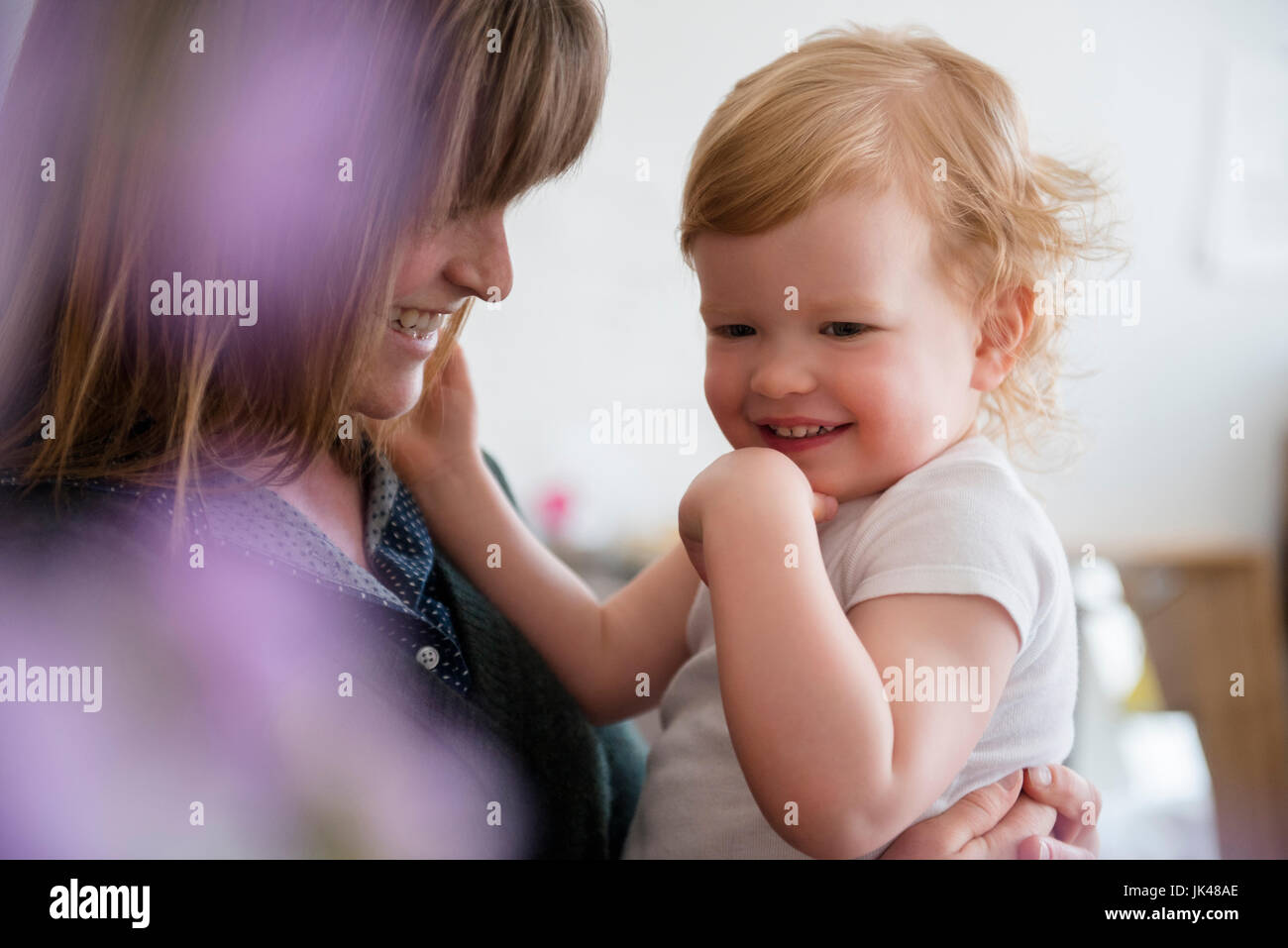 Madre caucasica holding ridere figlia Foto Stock
