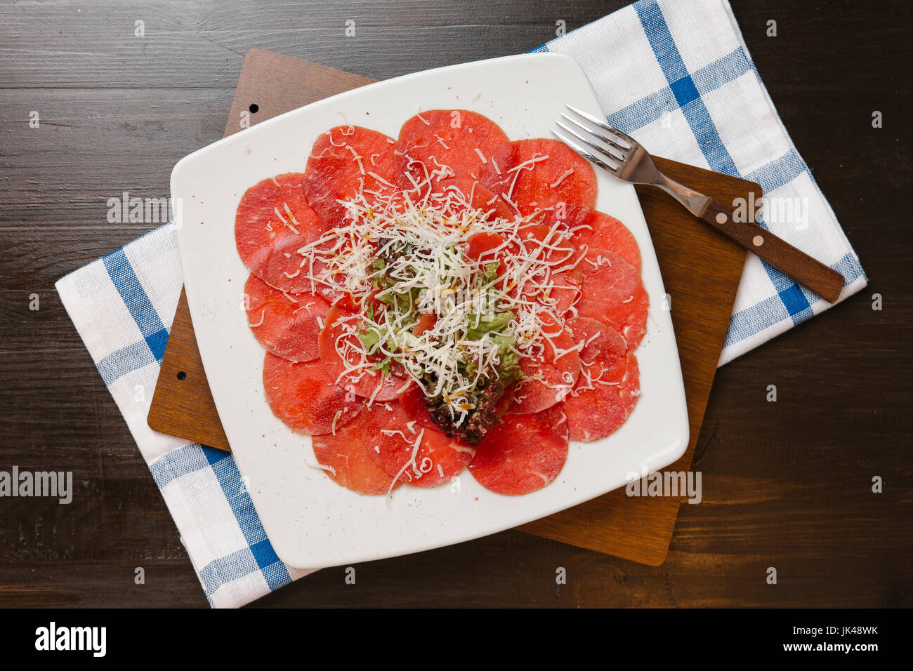 Formaggio grattugiato sulla piastra di carne tagliata a fettine Foto Stock