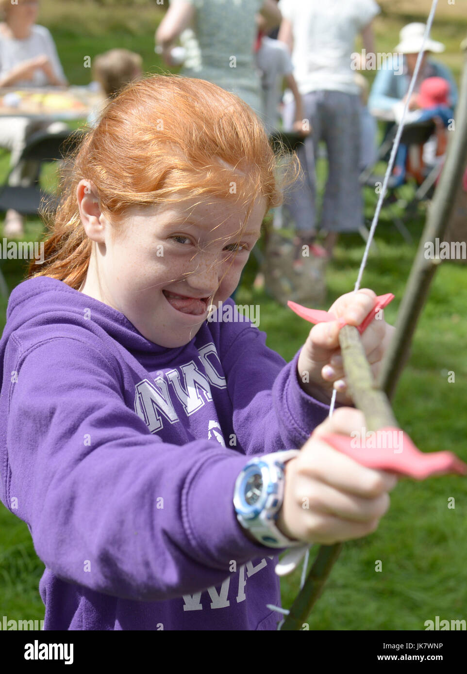 9 anno vecchia ragazza con i capelli rossi gioca con fatti in casa a base di arco e frecce Foto Stock