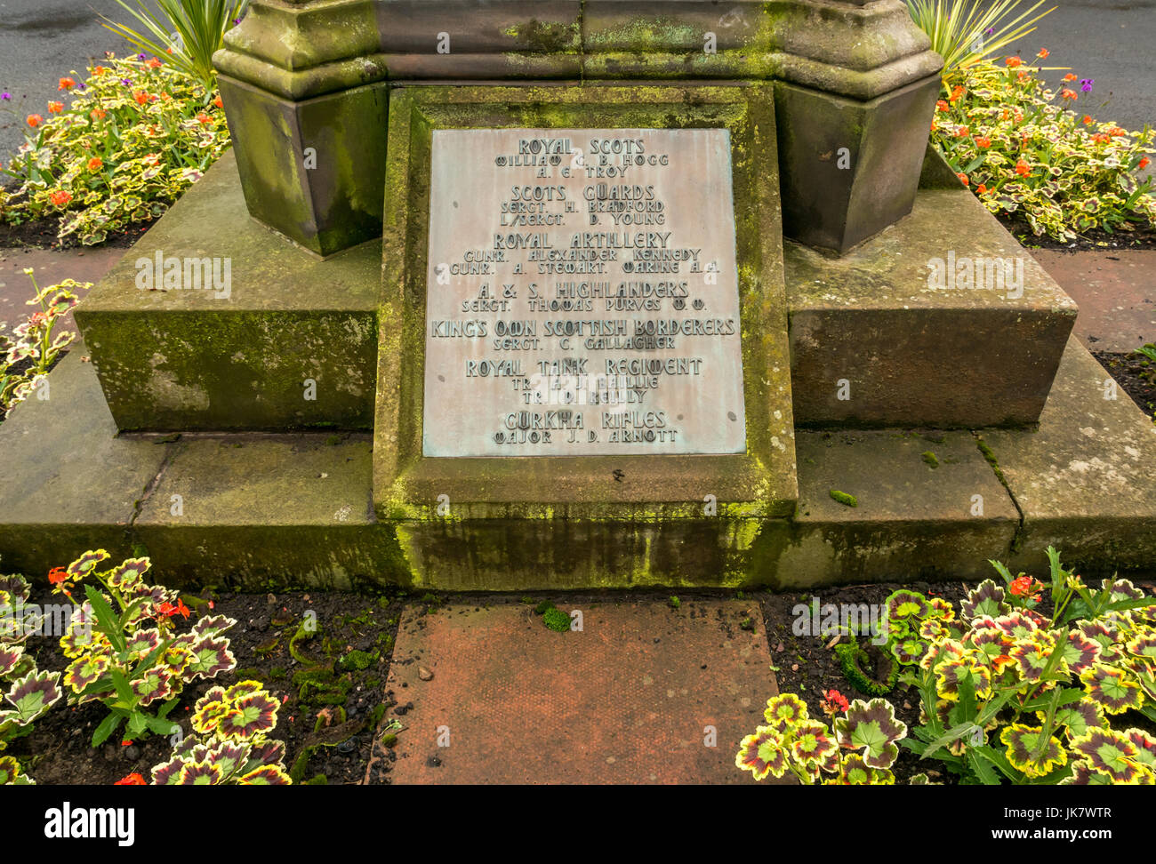 Memoriale di guerra elenco caduti nel sagrato, St Mary Chiesa Collegiata, Haddington, East Lothian, Scozia, con gerani Foto Stock