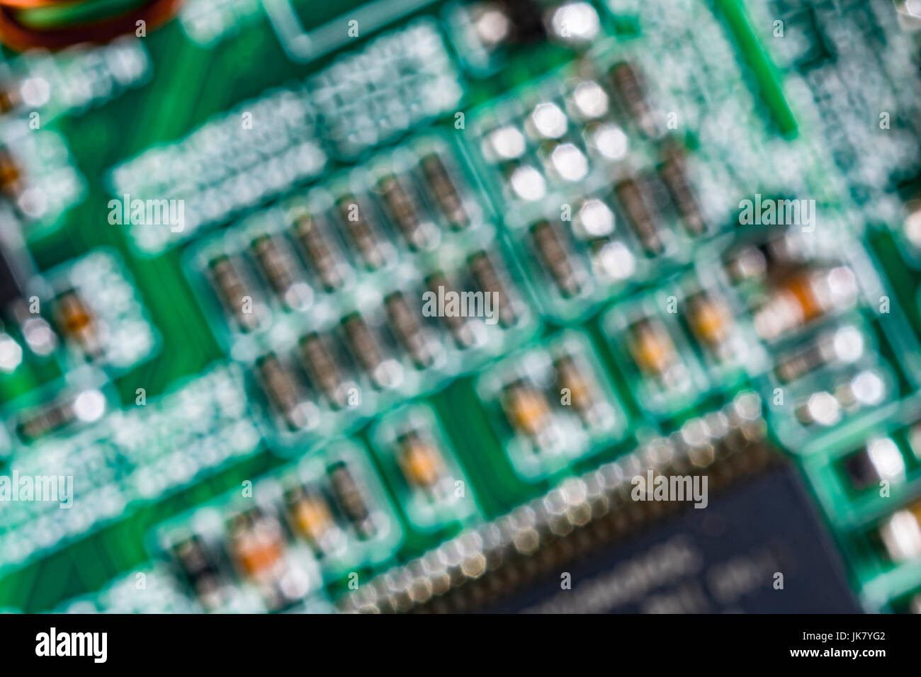 Al di fuori della messa a fuoco immagine di componenti su un verde scheda a circuito stampato (pcb). Foto Stock