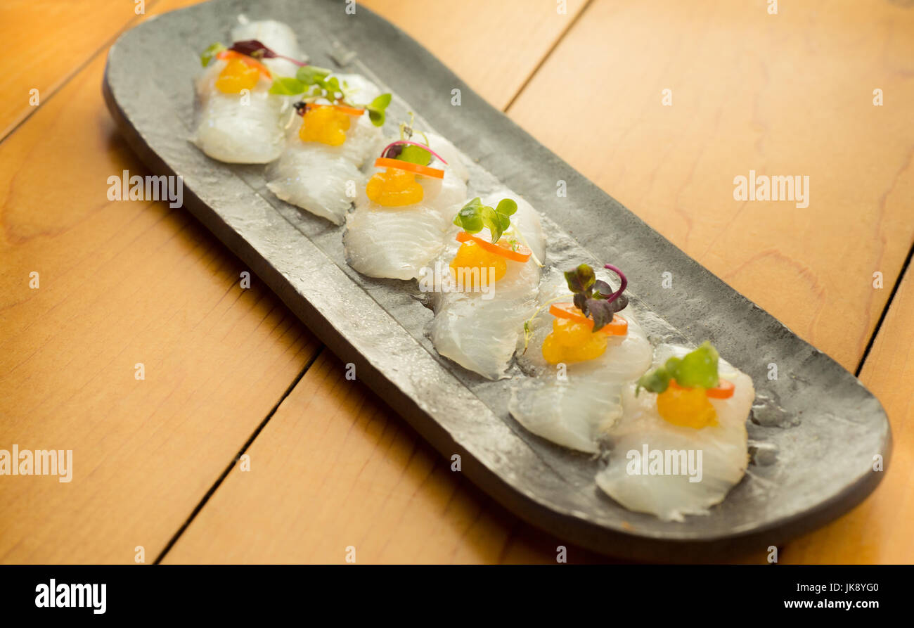 Elegante e colorato sushi di ippoglosso sulla piastra, pronto a mangiare. Foto Stock