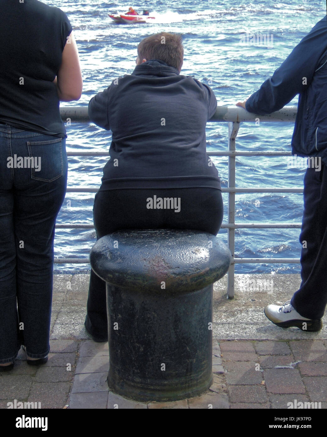 Obesi o in sovrappeso fat famiglia con bambino maschio sul sedile bollard Foto Stock