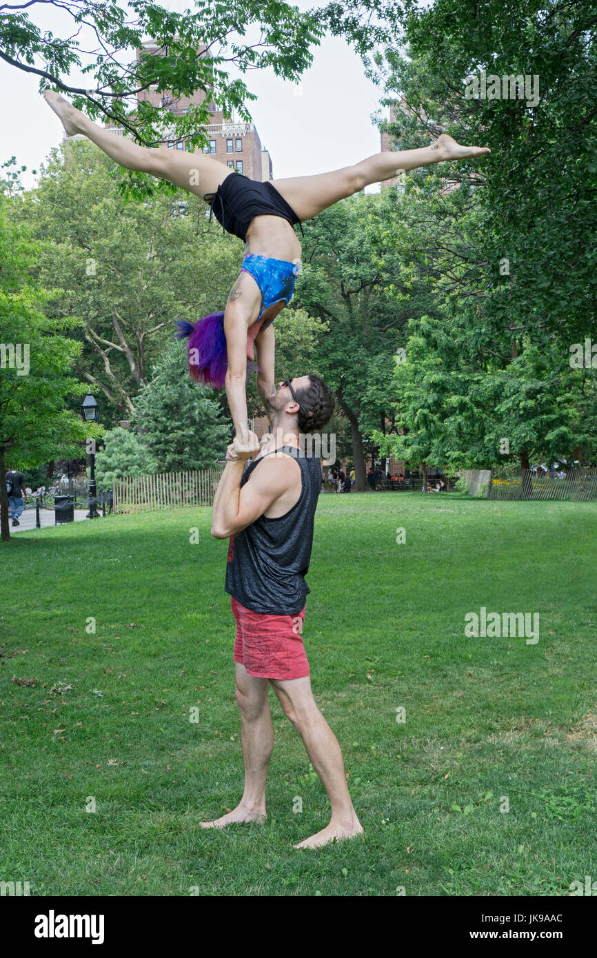 Vestibilità atletica giovane fare acro esercizi yoga in Washington Square Park di New York City. Foto Stock