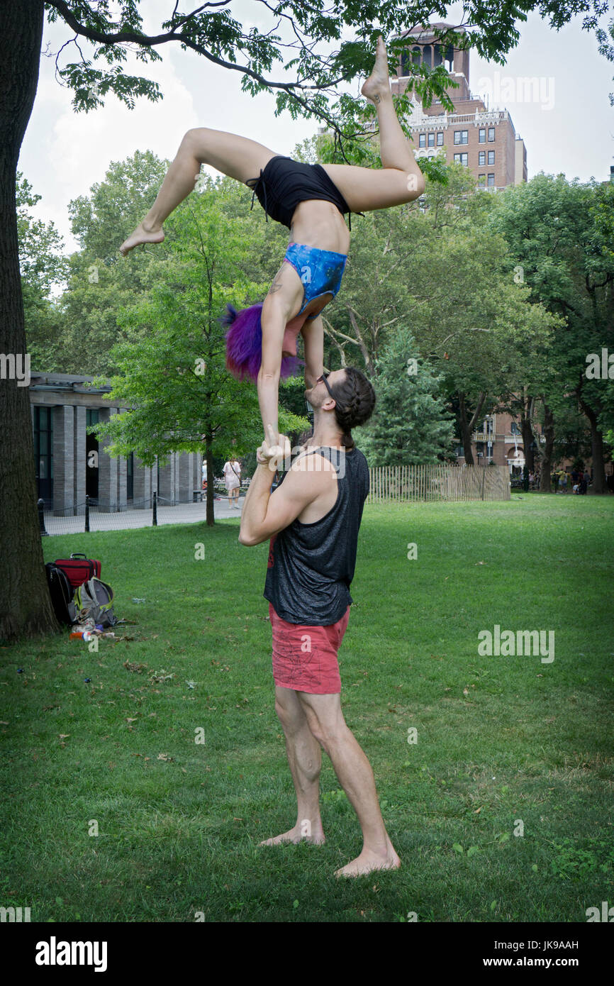Vestibilità atletica giovane fare acro esercizi yoga in Washington Square Park di New York City. Foto Stock
