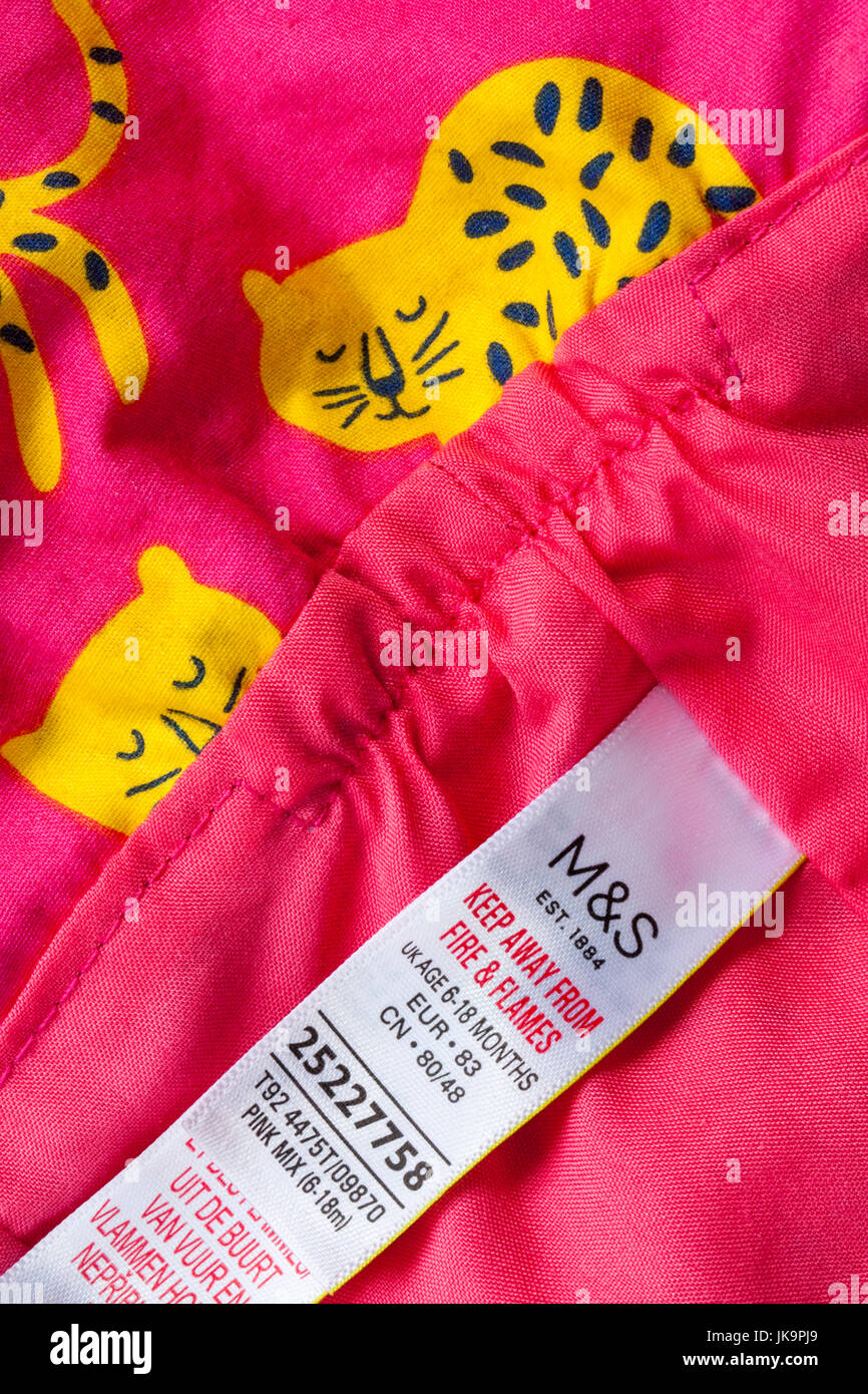 M&S etichetta in neonati cappello rosa con gatti giallo design - tenere lontano dal fuoco e fiamme Foto Stock