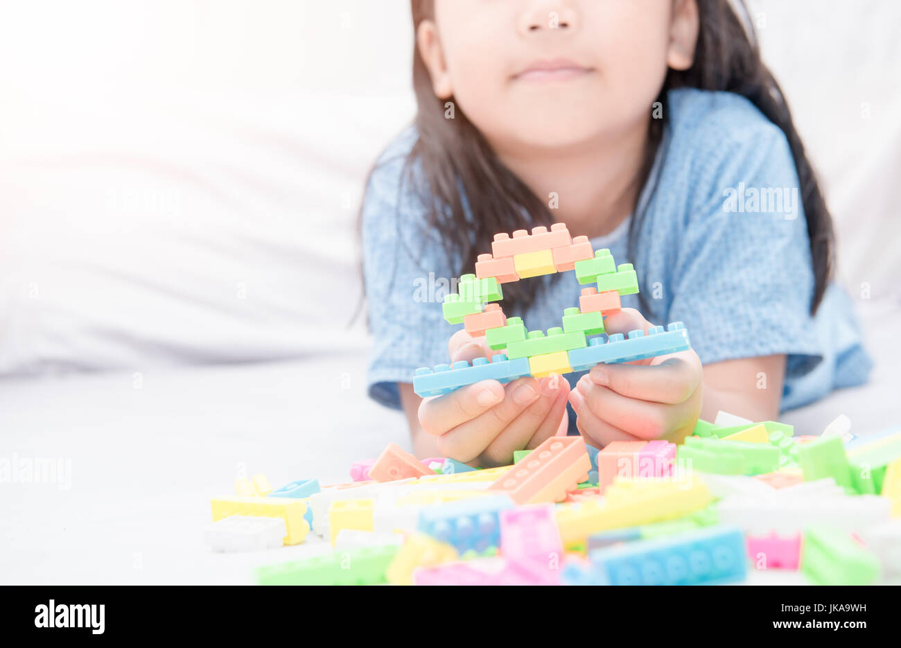Ragazza gioca block mattoni sul letto, il concetto di istruzione Foto stock  - Alamy
