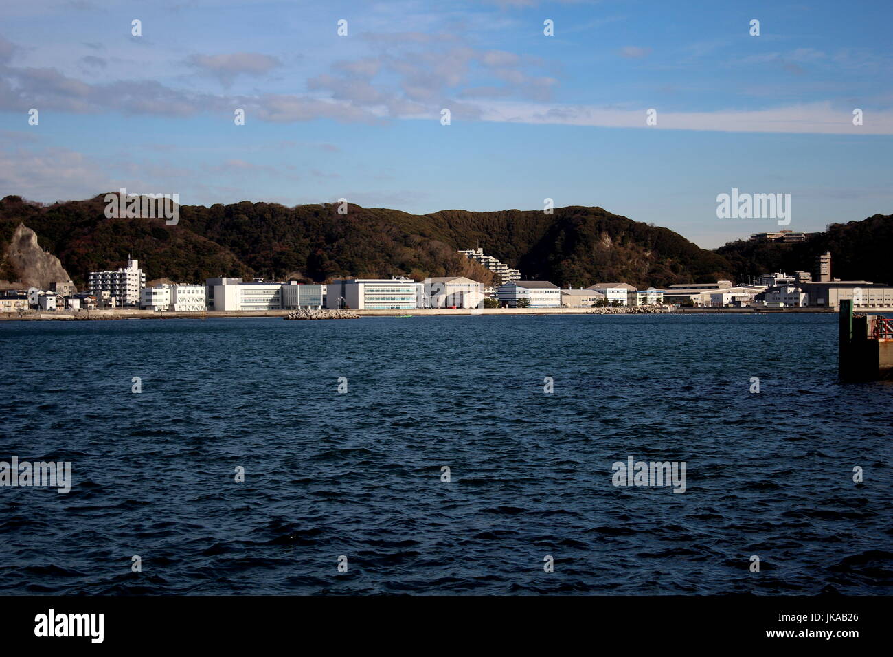 Edifici industriali attraverso il porto da Kurihama il porto per traghetti Foto Stock