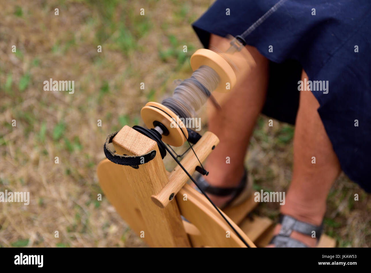 Close-up di filo andando sulla ruota di filatura bobina con motion blur Foto Stock