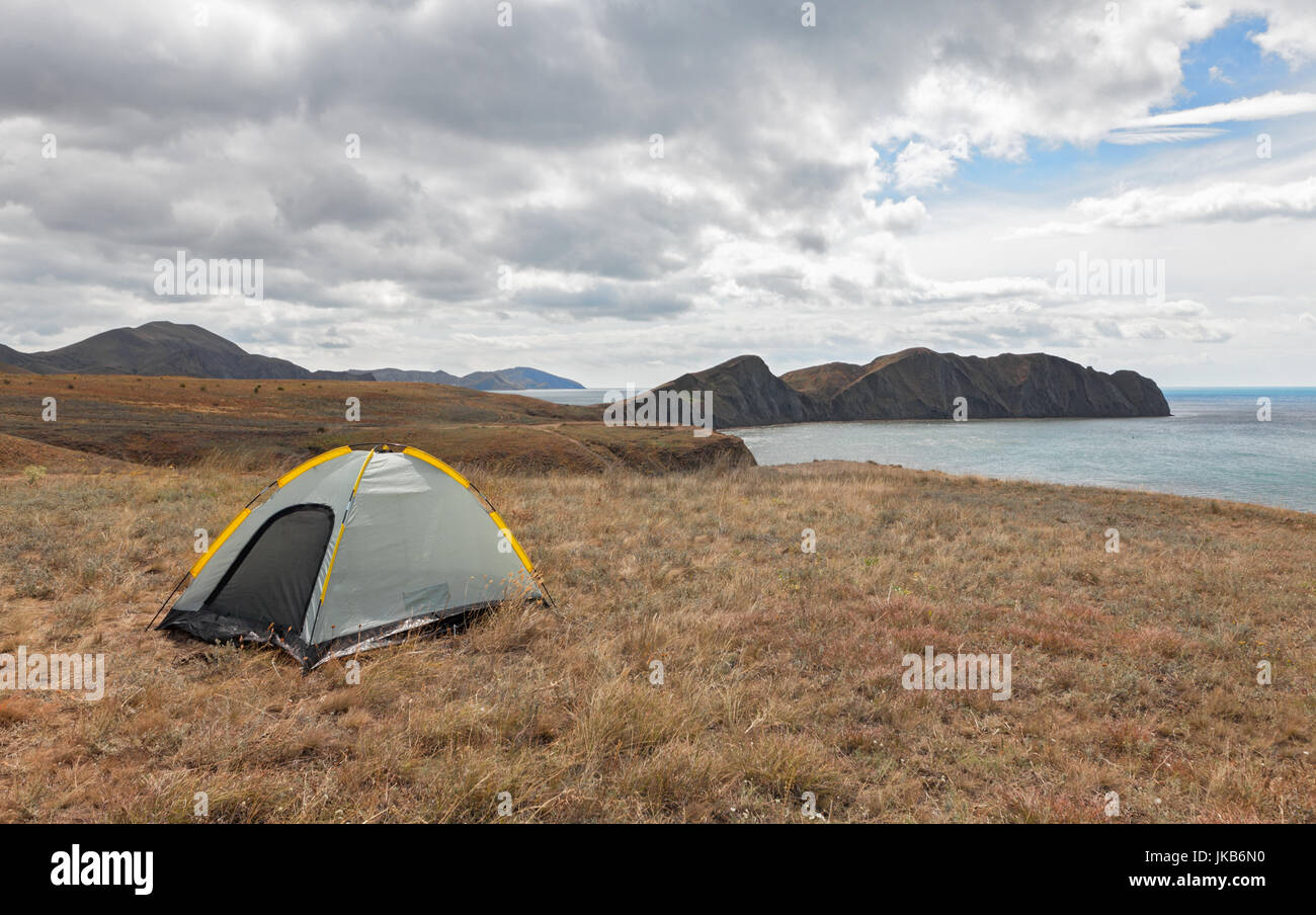 Tenda turistico su un promontorio vicino al mare di giorno in giorno. Il concetto di viaggio con le tende Foto Stock