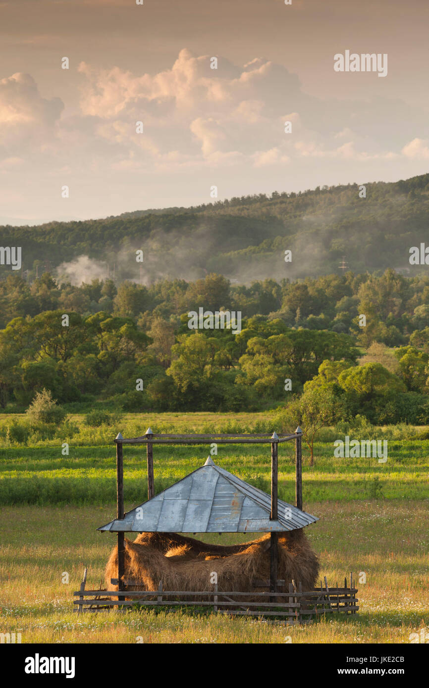 La Romania, regione Maramures, Sarasau, pagliaio dalla frontiera ucraino, tardo pomeriggio Foto Stock