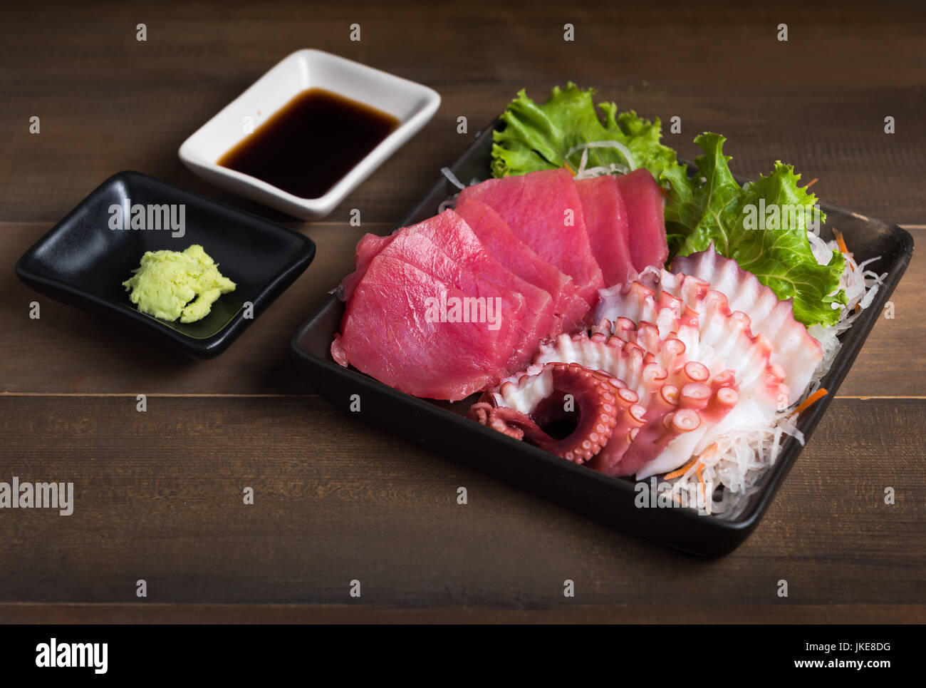 Sashimi di tonno e calamari su uno sfondo di legno, materie alimentari e il cibo giapponese Foto Stock