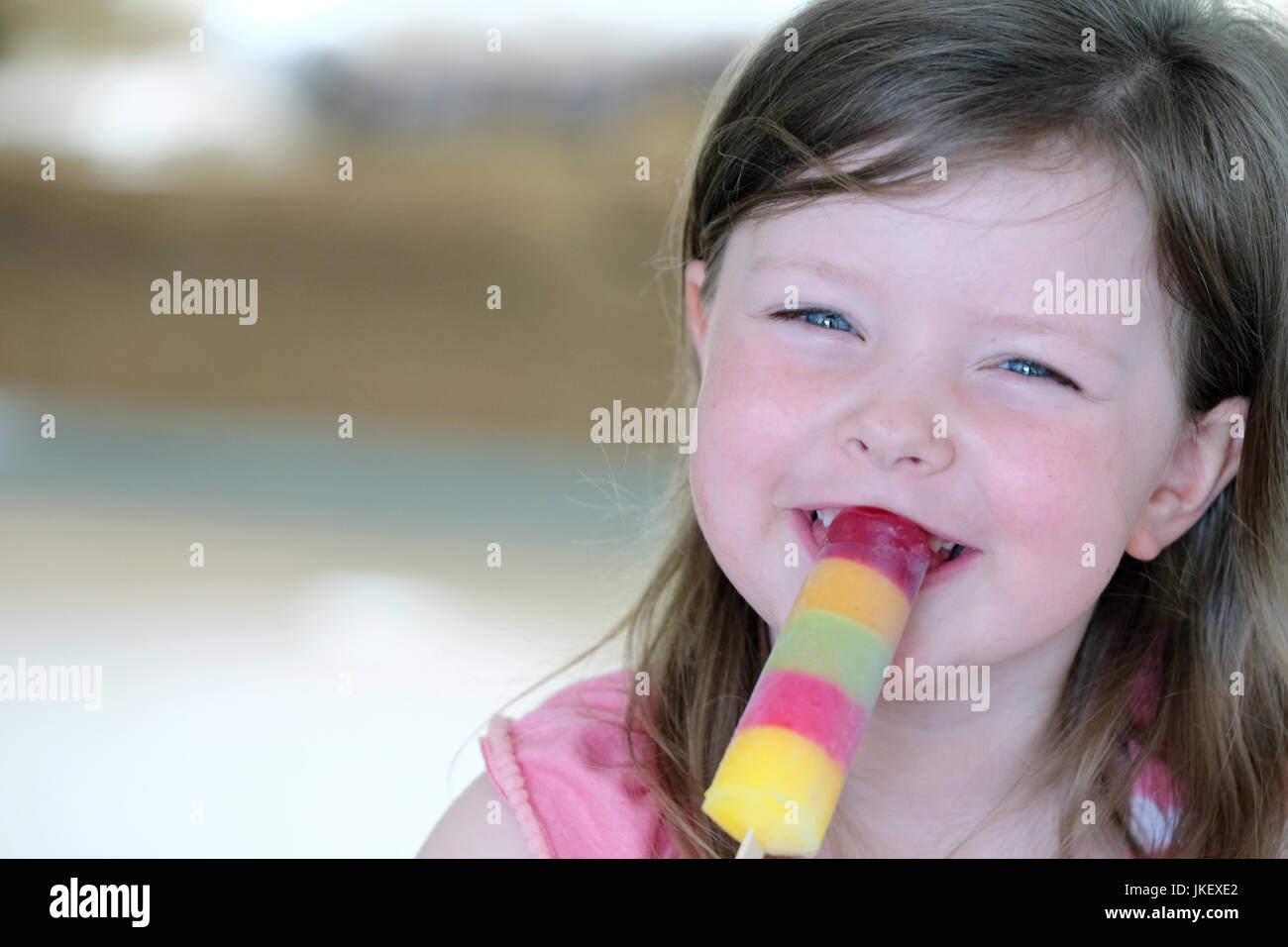 Un giovane bambino godendo di un multi-colore ghiaccio. per lecca-lecca scattate in ambienti chiusi in presenza di luce naturale. Foto Stock