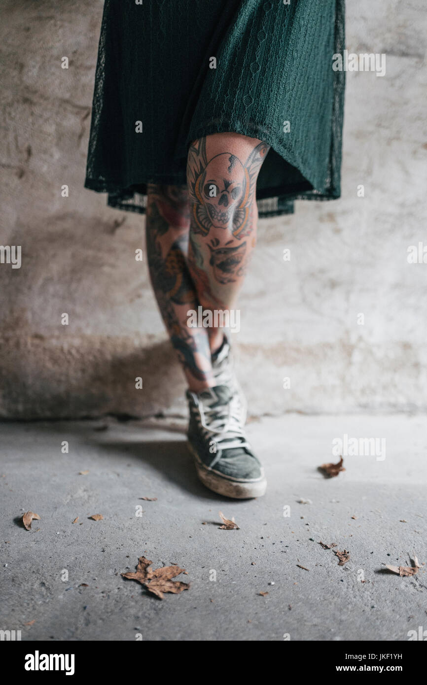 Le gambe di una giovane donna con tatuaggi Foto Stock