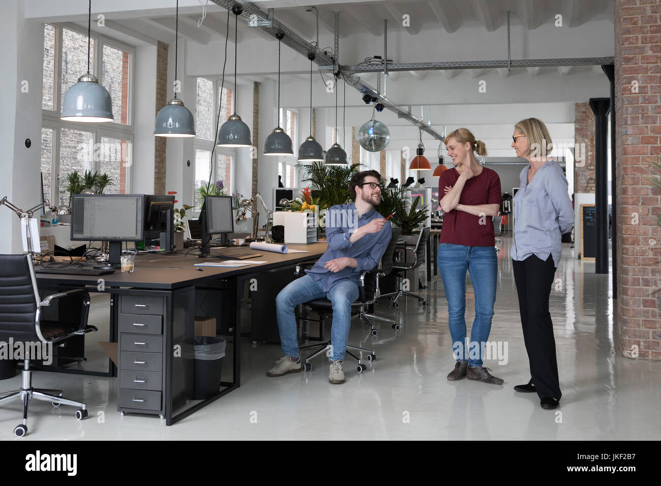 Gruppo di persone che parlano in ufficio Foto Stock