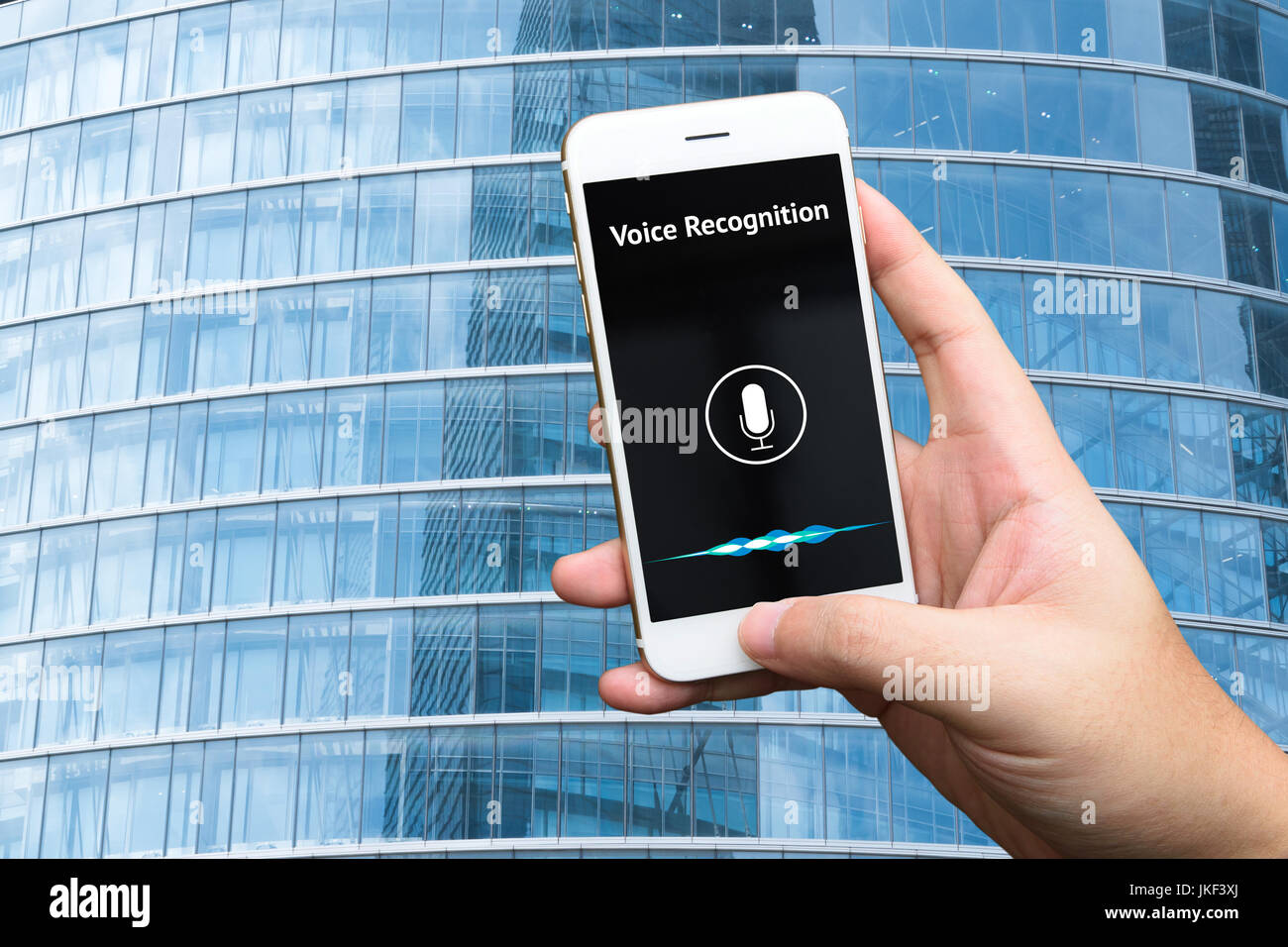 Il riconoscimento vocale , discorso di rilevare e profondo concetto di apprendimento. Applicazione sul telefono cellulare schermo con edificio blu sullo sfondo. Foto Stock