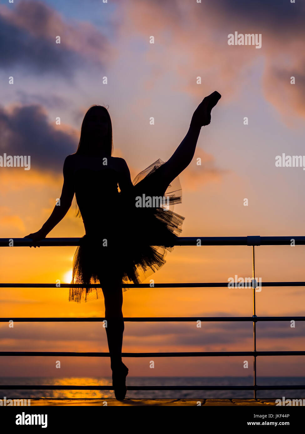 Silhouette di dancing ballerina in nero ballet tutu e pointe sul terrapieno  sopra l'oceano o mare all'alba o al tramonto. Attraente giovane donna  bionda w Foto stock - Alamy