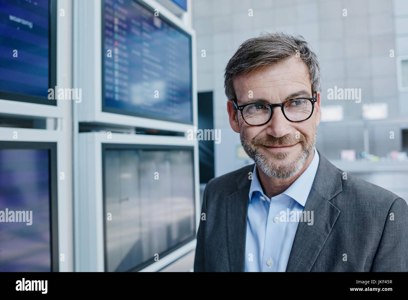 Imprenditore sorridente al calendario all'aeroporto Foto Stock