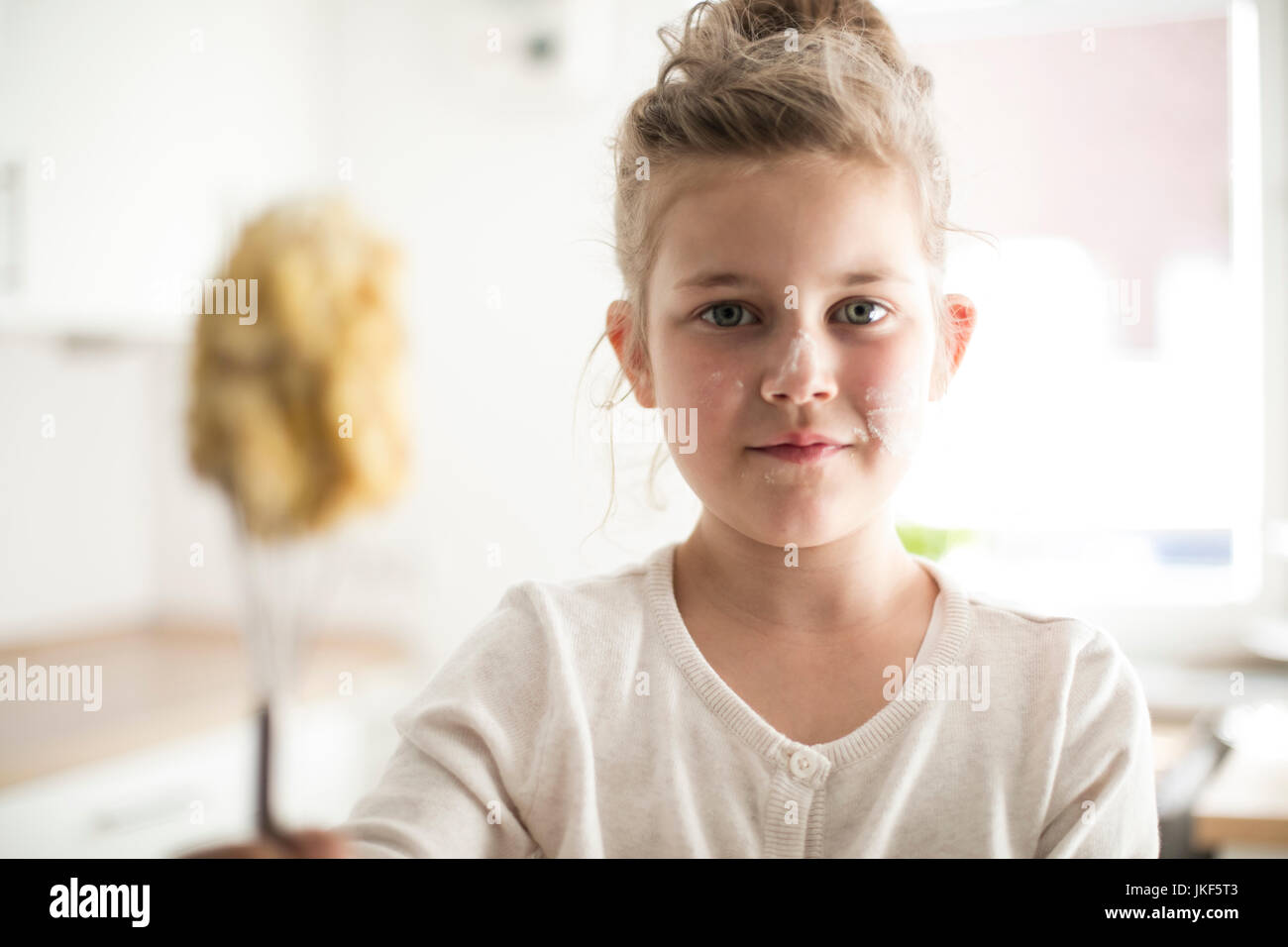 Ritratto di ragazza sorridente in cucina con la pasta sul suo viso Foto Stock