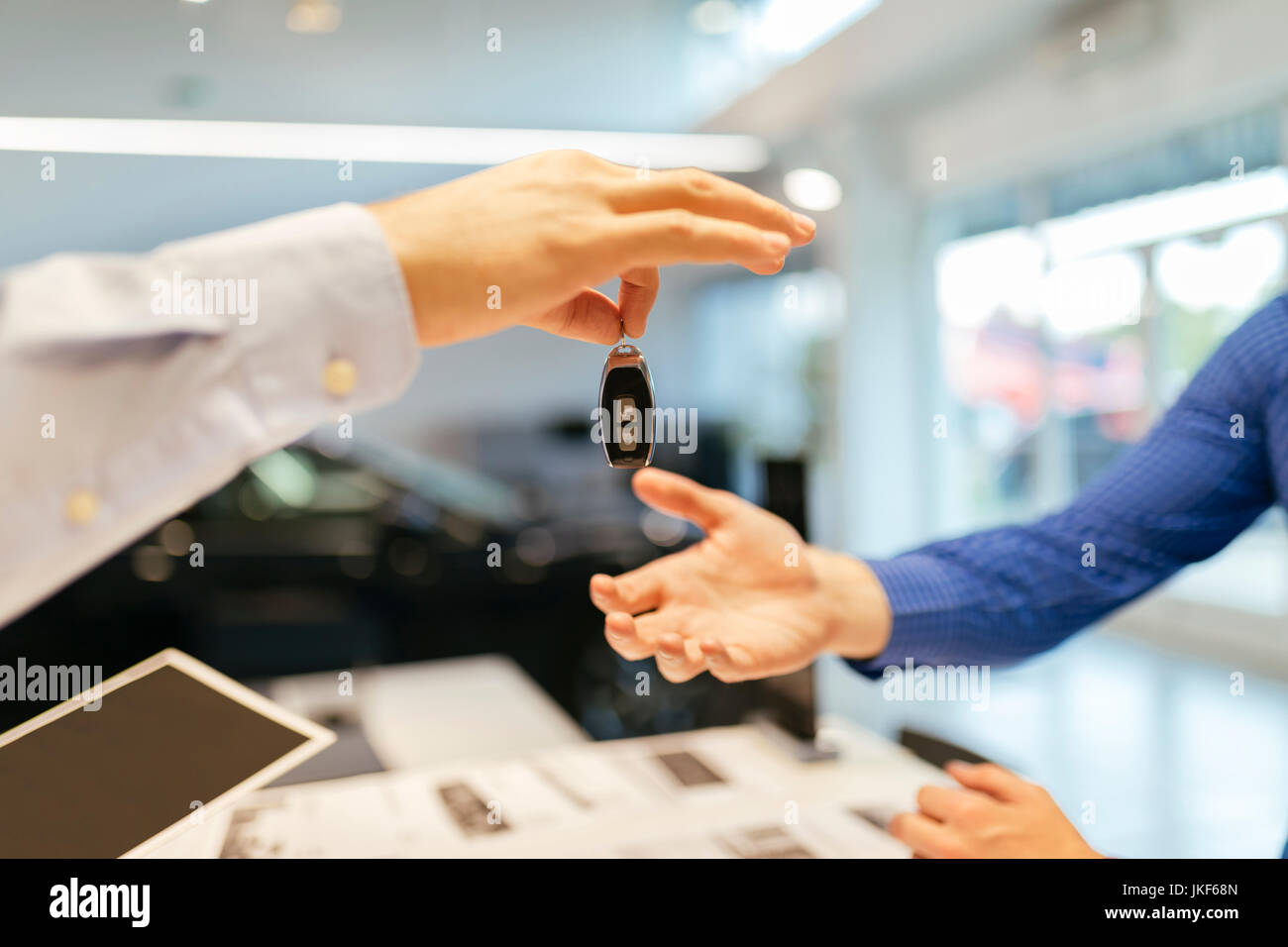 Addetto alle vendite consegna chiavi della macchina al cliente Foto Stock