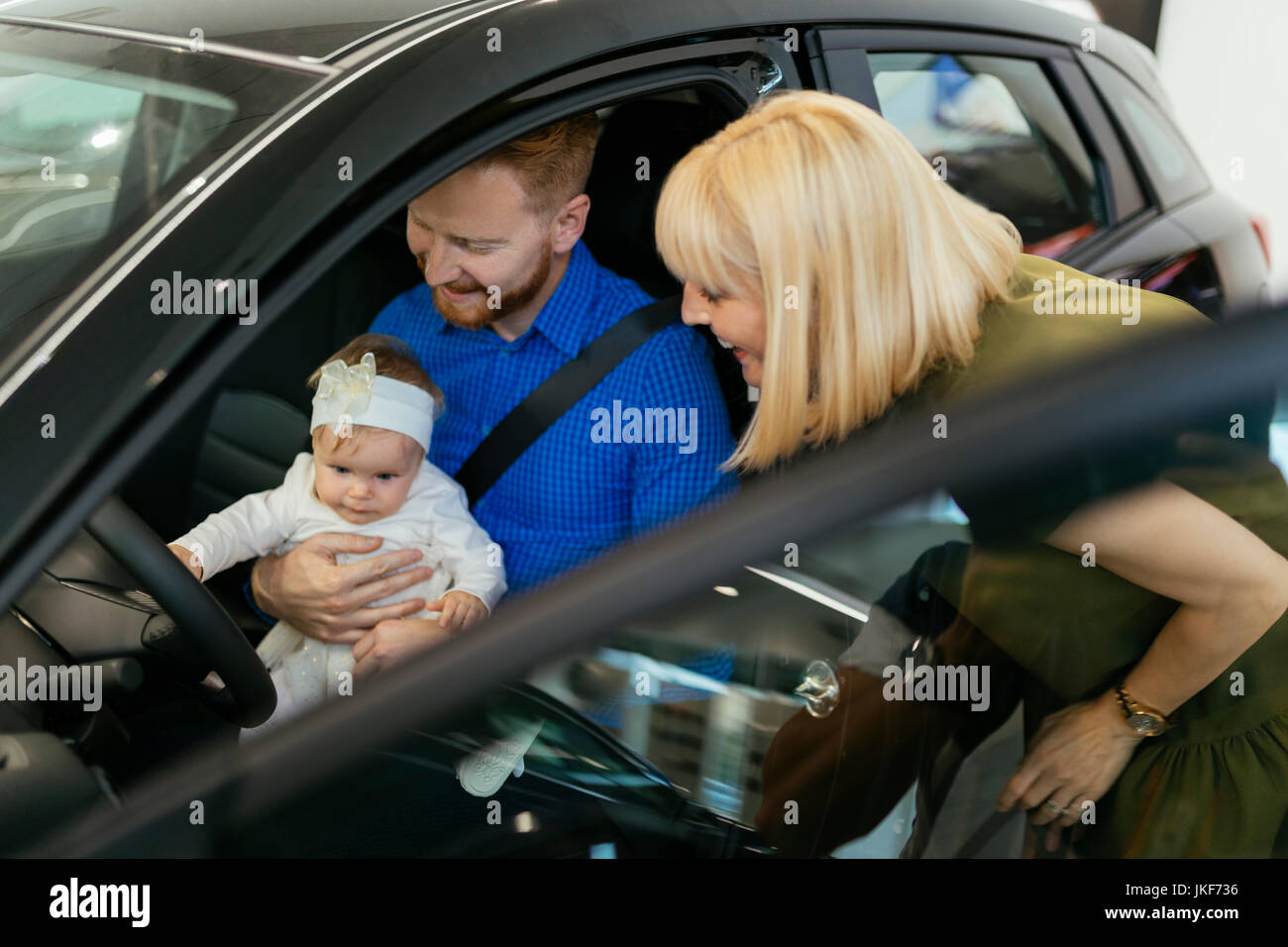 La famiglia scegliendo nuova famiglia di veicoli in concessionaria auto Foto Stock
