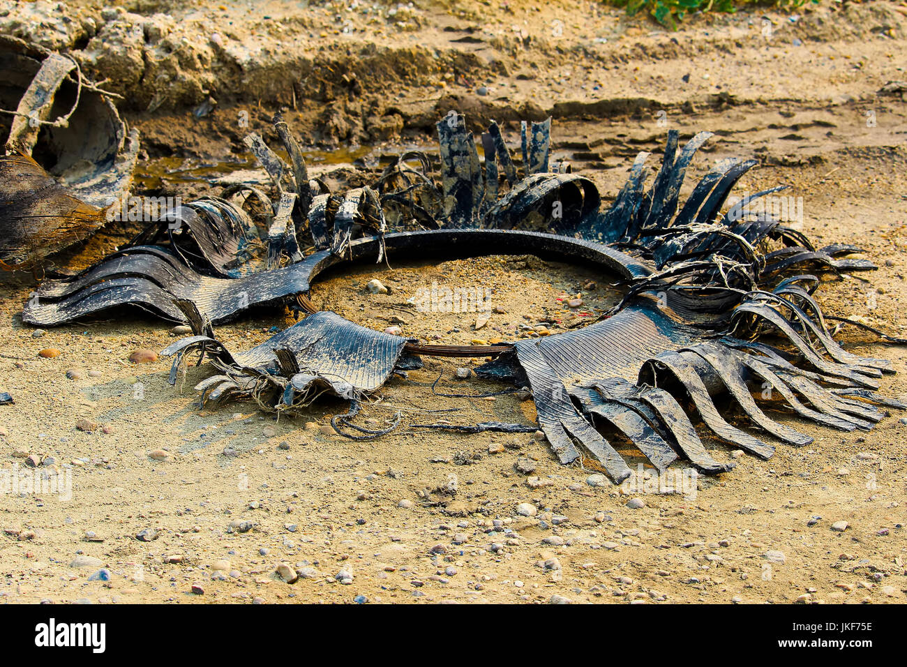 I resti di un pneumatico trinciato ancora sul suo tallone. Foto Stock