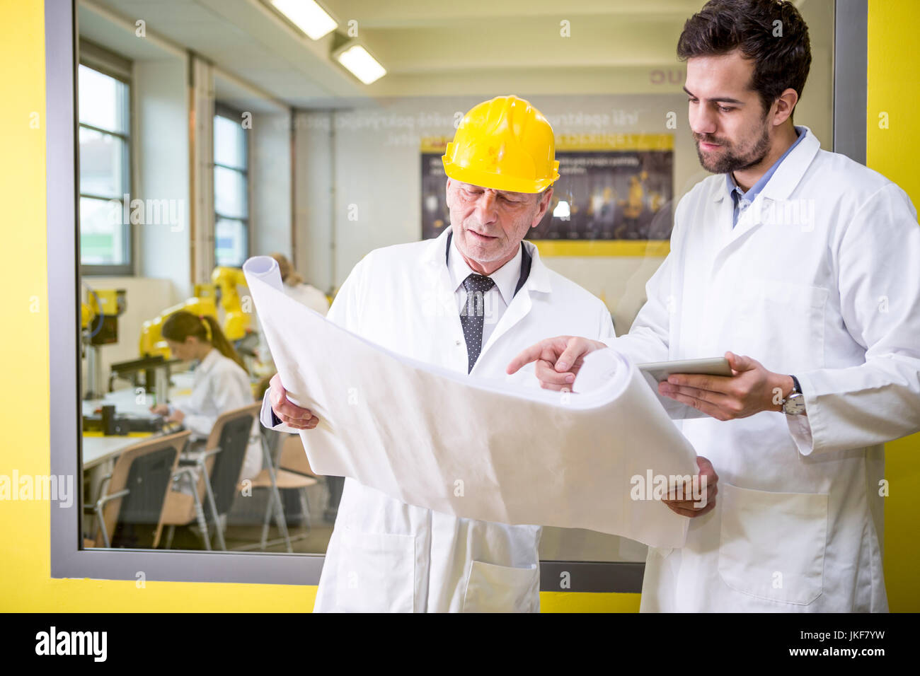 Due ingegneri in fabbrica guardando al plan Foto Stock