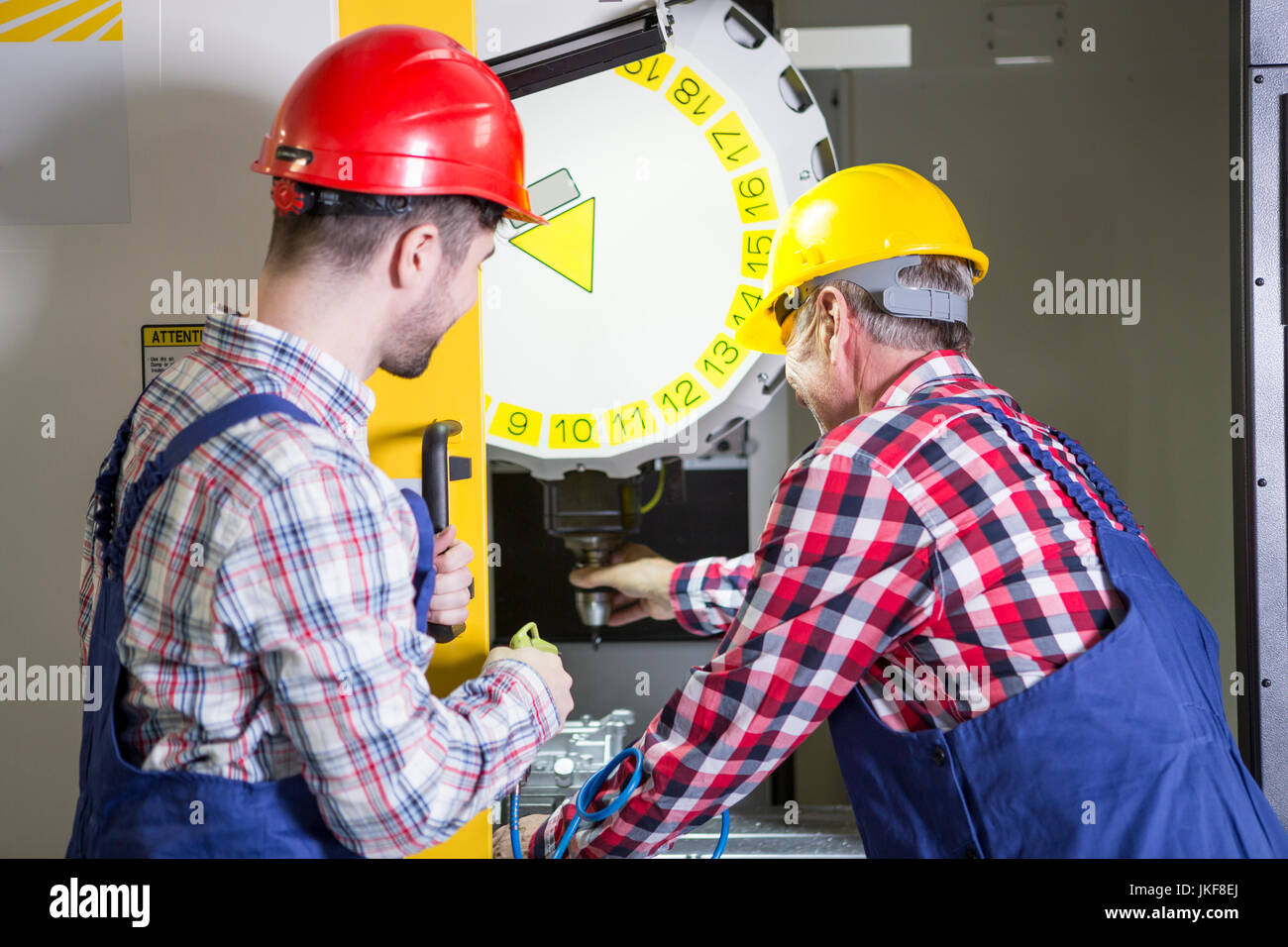 Due uomini in fabbrica e lavorare a macchina CNC Foto Stock