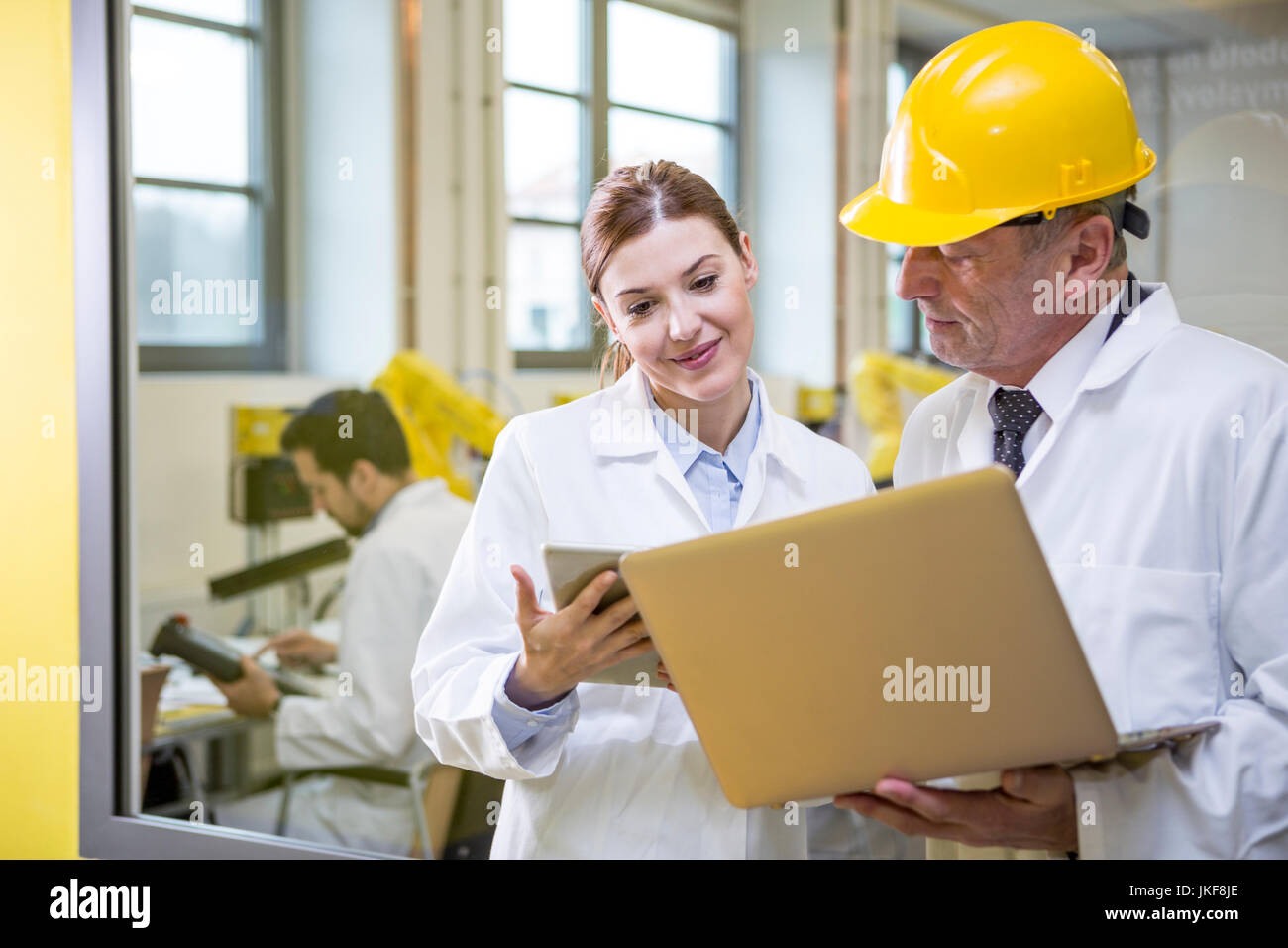 Due ingegneri in fabbrica con tablet e laptop Foto Stock