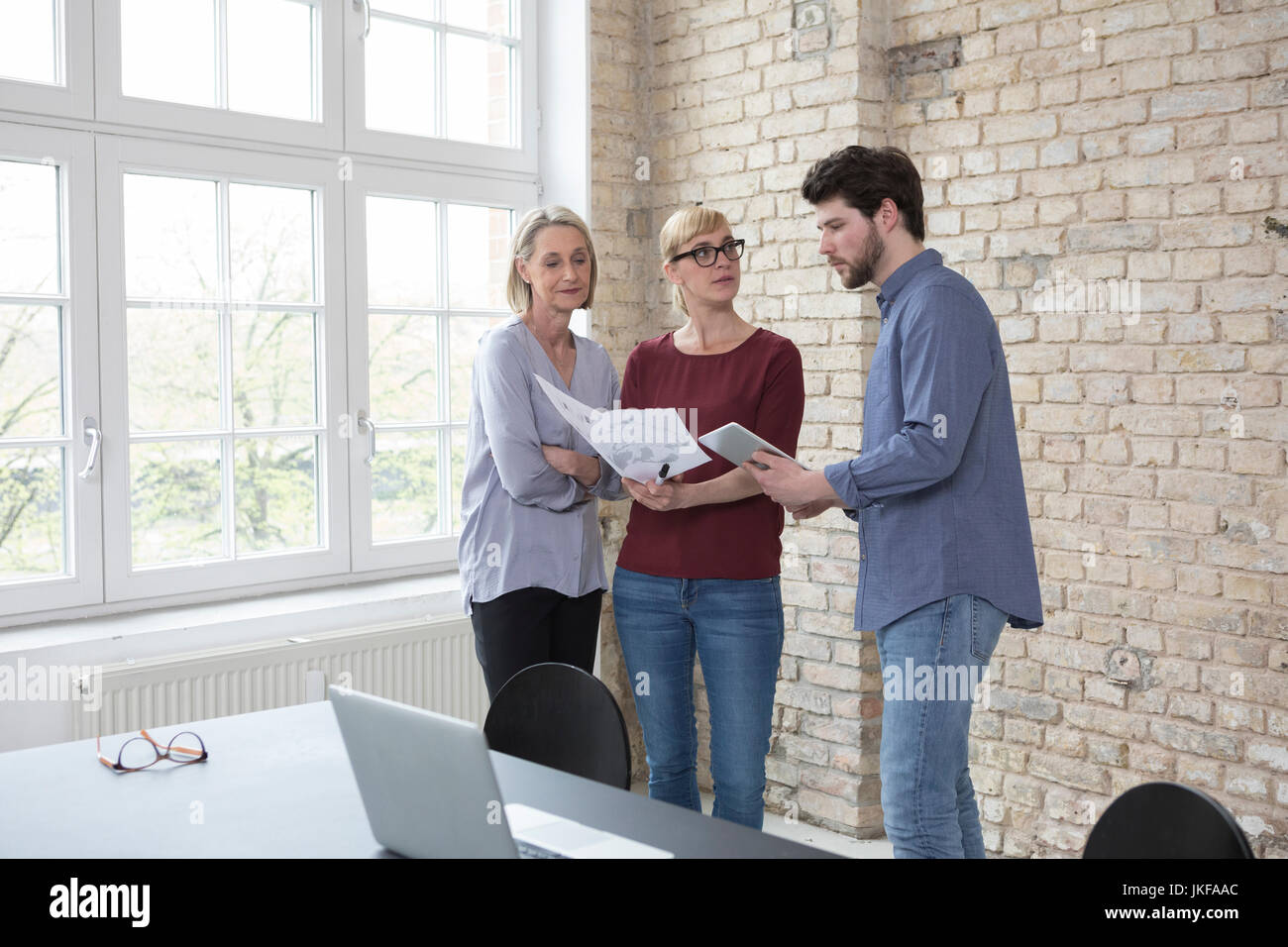 Coppia imprenditrice lavora con il collega più giovane in office Foto Stock