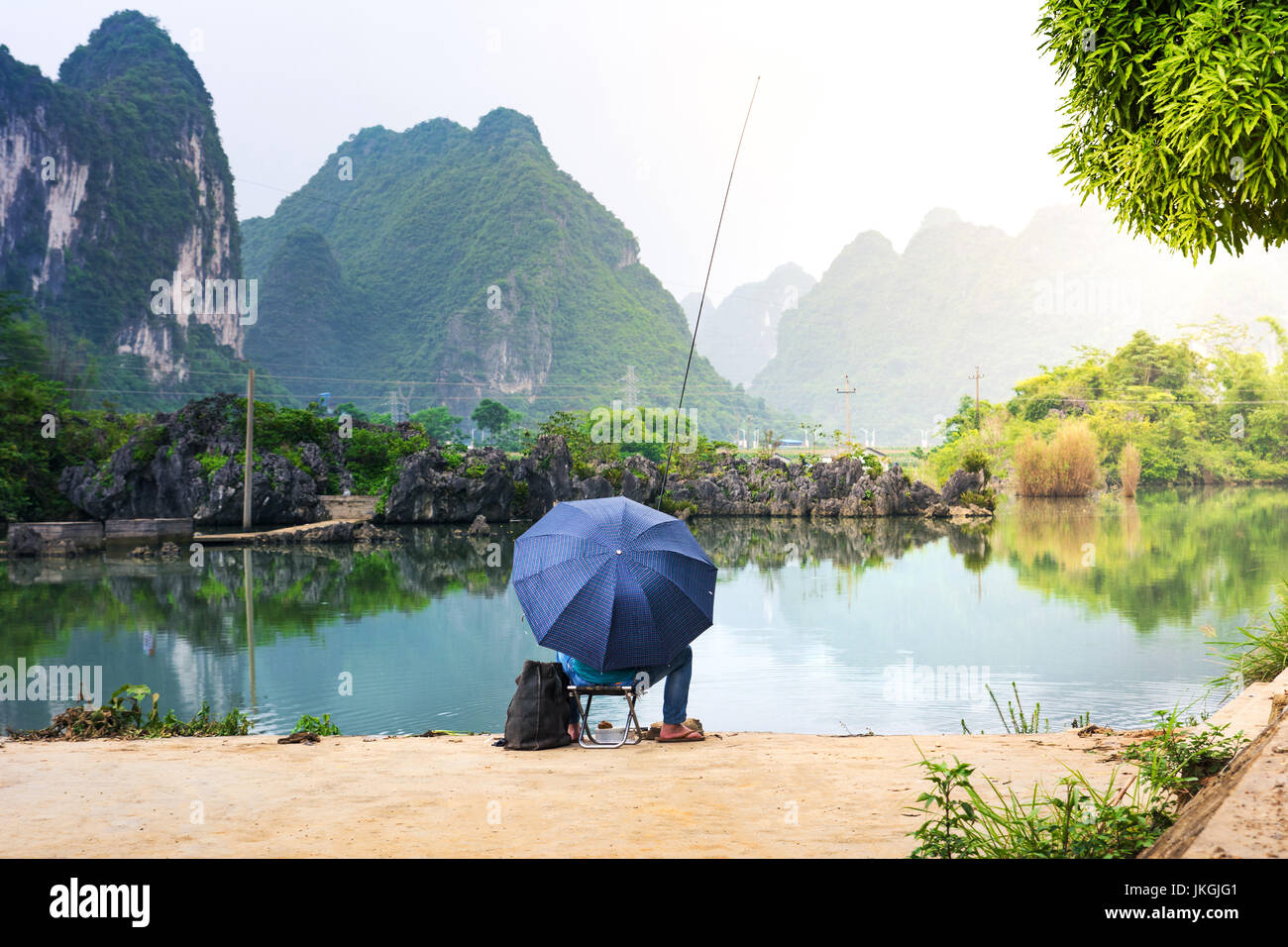 Pescatore solitario in un pittoresco lago della provincia di Guangxi in Cina Foto Stock