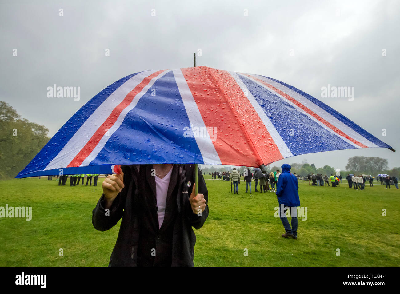 Unione britannica bandiera ombrello durante la pioggia e il tempo umido nell'Hyde Park di Londra. Foto Stock