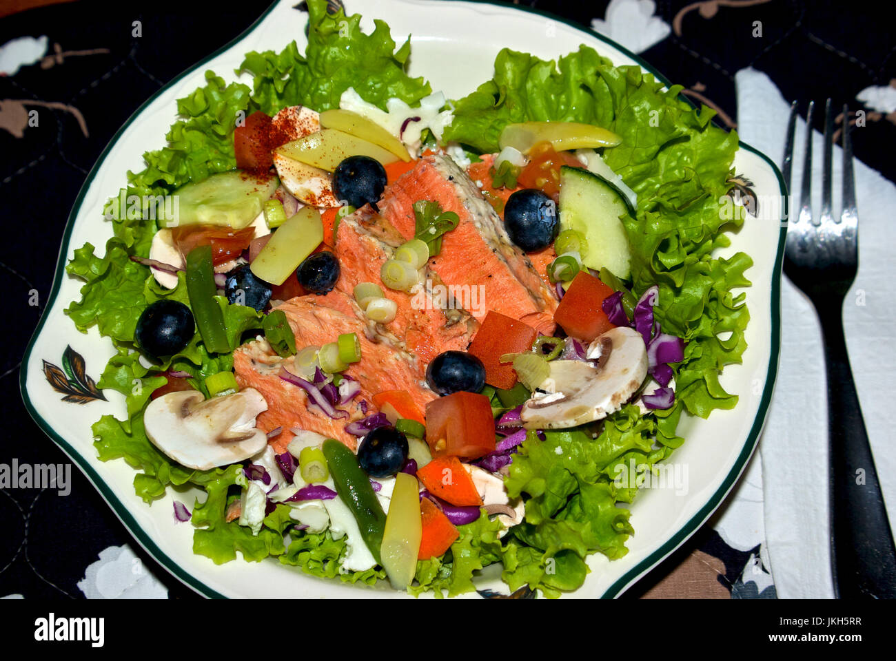 Salmone alla griglia con insalata di mirtilli, fagiolini, carote funghi, cetriolo, pomodori, lattuga, cavolo rosso Foto Stock