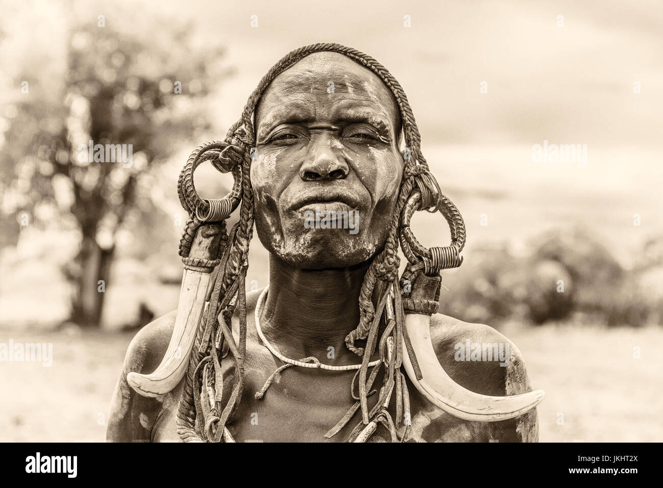 Guerriero dalla tribù africana Mursi con corna tradizionali nel Parco Nazionale di Mago, Etiopia. Vintage in bianco e nero elaborata. Foto Stock