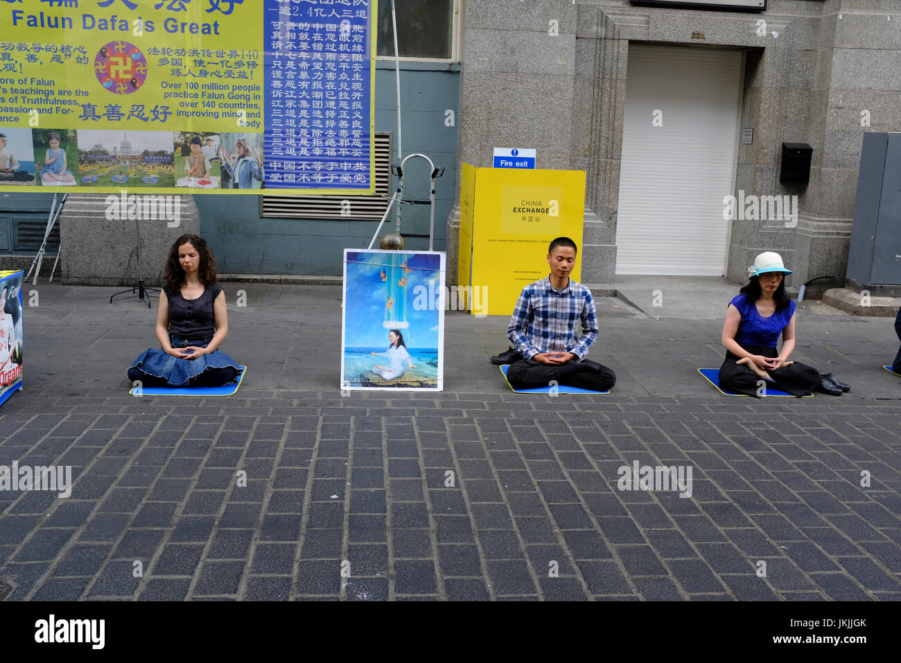 I membri della setta Falun Gong meditando sulla strada a Chinatown a Londra, Inghilterra, Regno Unito Foto Stock